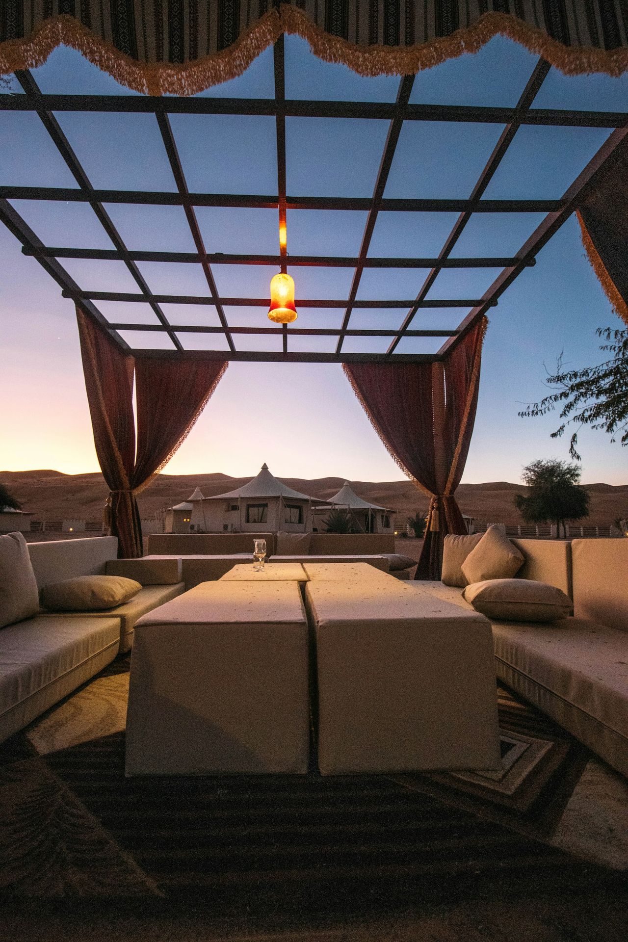 A king bed open to the landscape at dusk