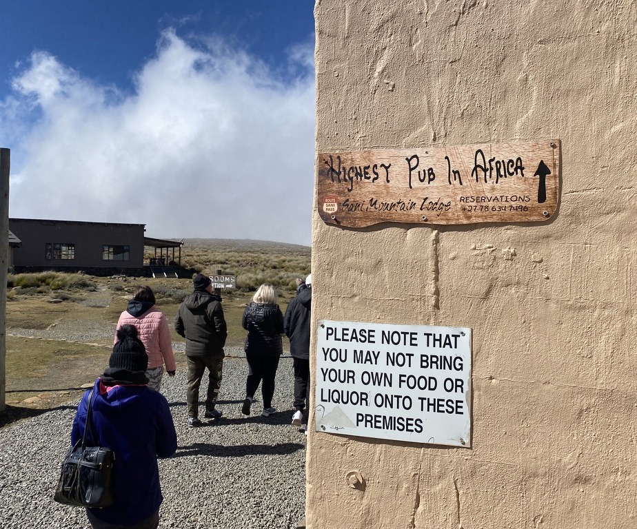 Hand-painted sign pointing to the Highest Pub in Africa at Sani Top